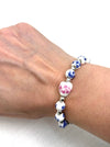 Bracelet with floral beads on a wrist against a white background