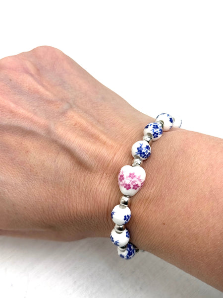 Bracelet with floral beads on a wrist against a white background