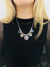 Necklace with colorful beads worn by a person against a neutral background