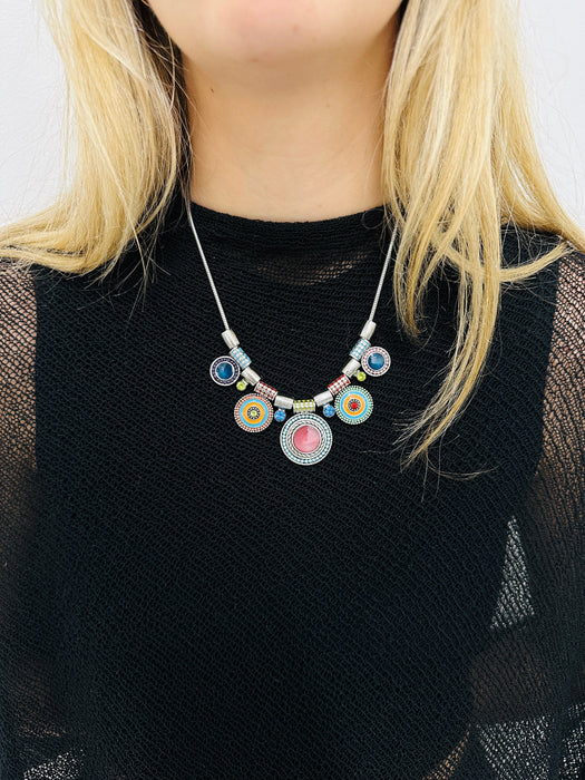 Necklace with colorful beads worn by a person against a neutral background
