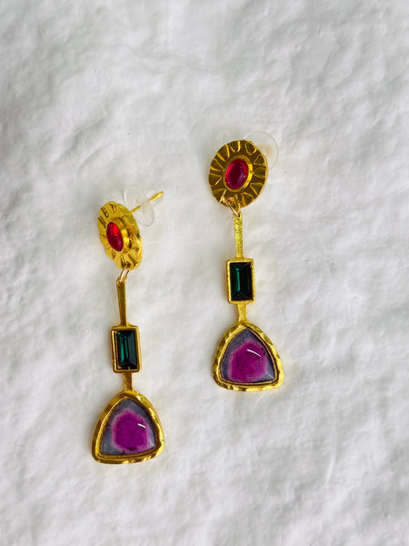 flat -lay view of gold earrings on a white background