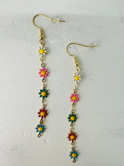 A pair of colorful floral dangle earrings with gold-colored metal and multicolored gemstone-like accents, displayed against a neutral background.