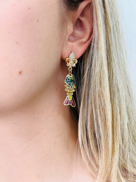 Close-up of a person wearing a colorful earring with a detailed design.