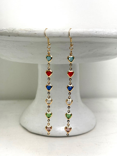 Multicolored heart-shaped bead earrings on a white pedestal
