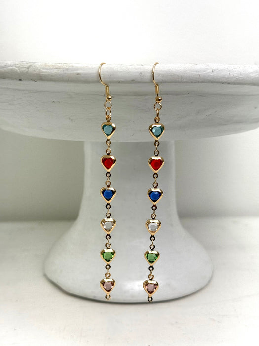 Multicolored heart-shaped bead earrings on a white pedestal