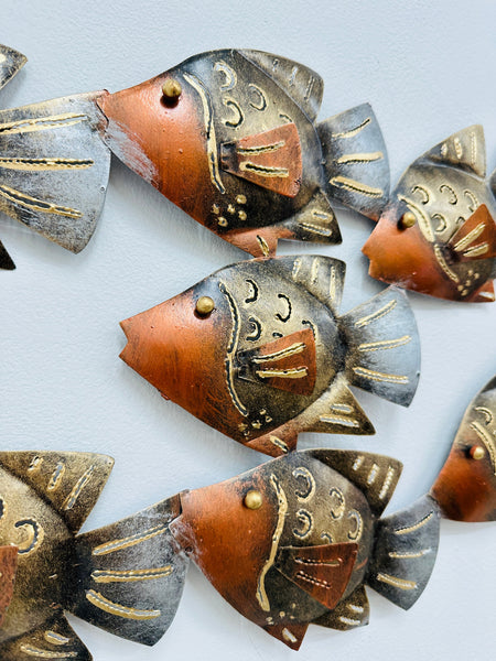 Close-up of copper mottled metal fish showing engraved detailing and gold accents