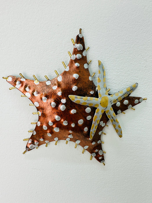 Copper starfish wall art hanging on white wall, hand-painted with raised texture