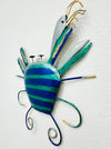 Angled view of blue metal crab wall art showing painted details and raised claws