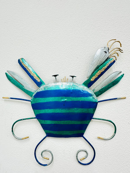 A hand-painted blue metal crab wall art with a mix of geometric patterns and organic shapes.