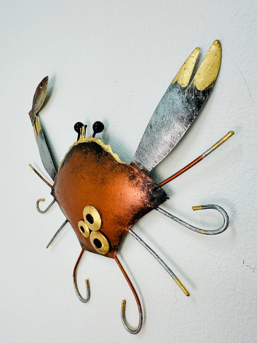 Angled view of copper metal crab wall art showing hand-painted texture and raised details