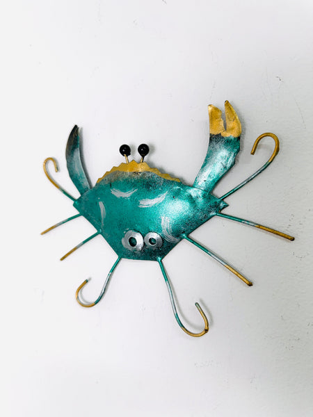 Angled view of green metal crab wall art showing painted texture and raised legs