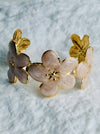 Floral bracelet with gold accents on a textured surface
