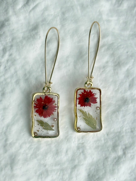 Pair of earrings with floral design on a white background