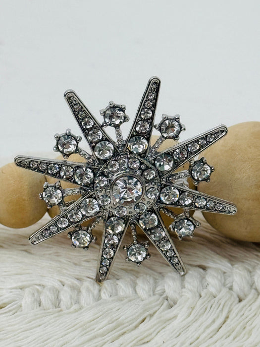Decorative brooch with crystal details on a textured surface