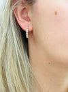 Close-up of a daisy silver hoop earring 