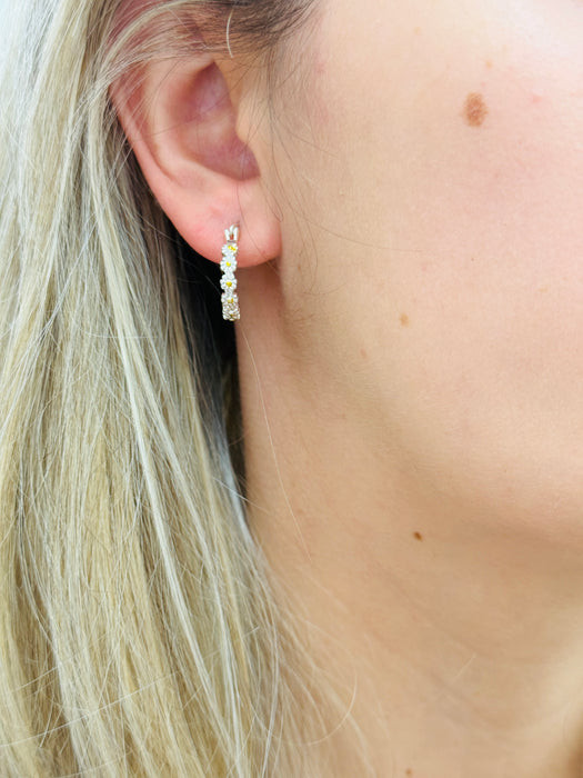 Close-up of a daisy silver hoop earring 