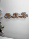 Three decorative wall-mounted fish sculptures in a row, featuring brown and white scales with gray fins, displayed on a plain white wall.
