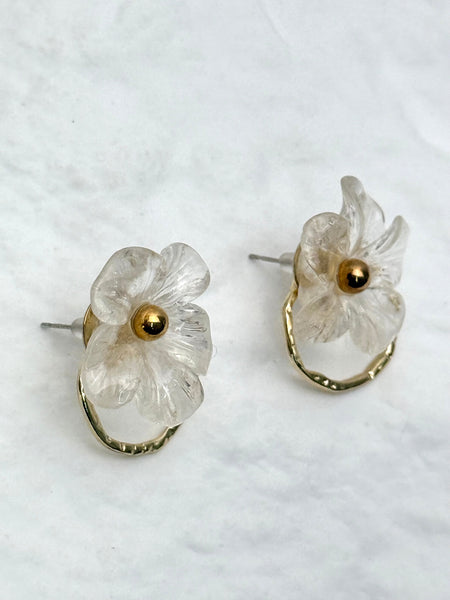 Floral earrings with gold centers on a light background
