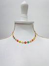 Colorful floral necklace on a mannequin against a white background