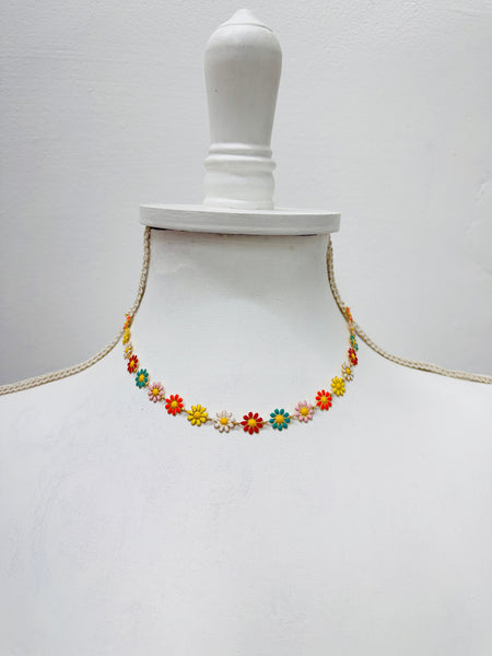 Colorful floral necklace on a mannequin against a white background