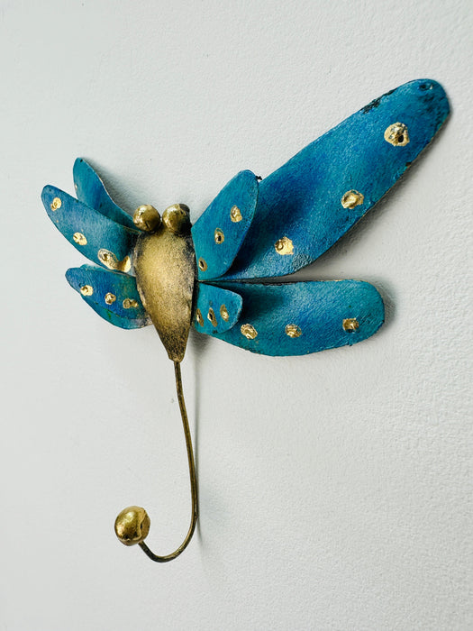 Handmade and hand painted metal wall hook in the shape of a dragonfly with turquoise color and gold accents