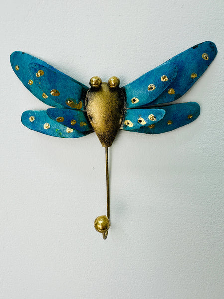 Handmade turquoise metal dragonfly hook with silver and gold accents on white background.