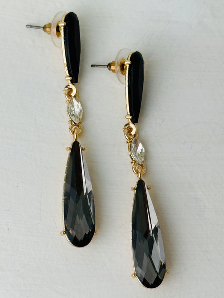 Elegant 7 cm long drop earrings with black stones, clear crystal and smoky teardrop in gold-tone finish.