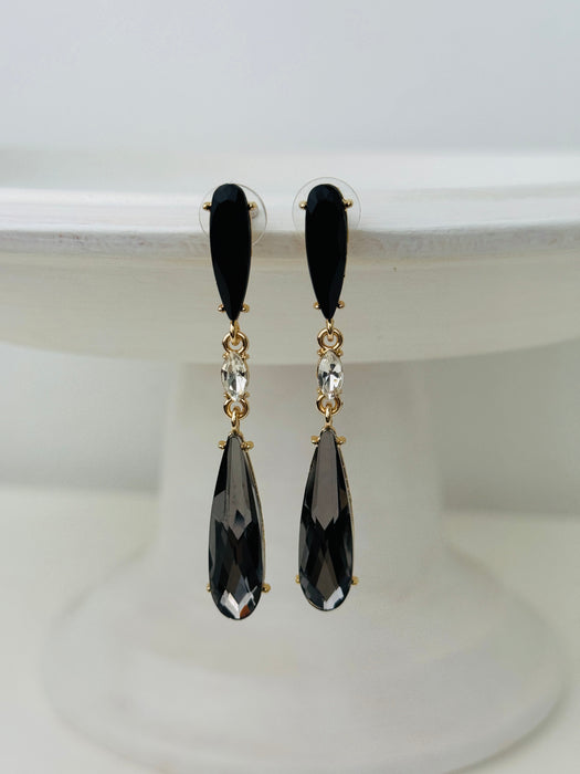 Elegant 7 cm long drop earrings with black stones, clear crystal and smoky teardrop in gold-tone finish, displayed on a white background.
