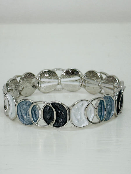 Elastic Aurea bracelet with white and grey enamel circular design.