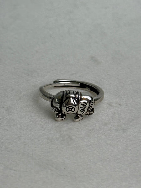 Silver ring with a detailed design on a light gray background