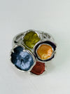 Close-up of silver-tone elastic ring with coloured  lily pad detailing.