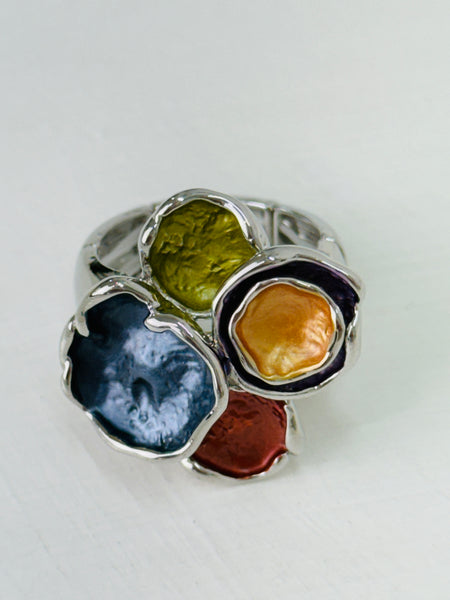 Close-up of silver-tone elastic ring with coloured  lily pad detailing.