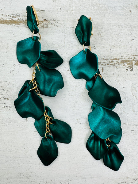 12 cm long statement drop earrings with cascading matte dark green acrylic petals and gold-tone metal accents, displayed on a table.