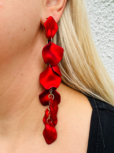 12 cm long statement drop earrings with cascading matte red acrylic petals and gold-tone metal accents, displayed on a model.