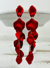 12 cm long statement drop earrings with cascading matte red acrylic petals and gold-tone metal accents.