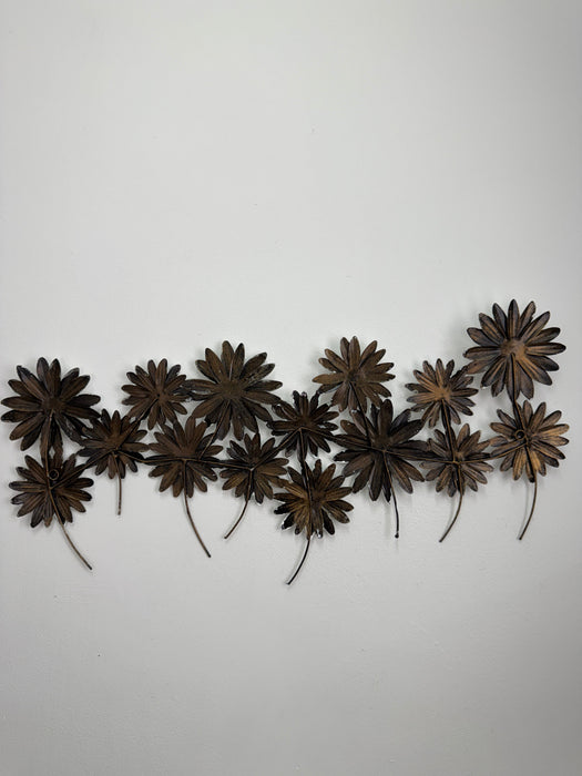 Back view of the metal daisy wall sculpture showing hanging structure