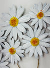 Close-up of metal daisies showing hand-painted petals and yellow centres