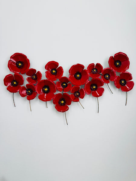 Hand-painted red metal poppy wall sculpture with layered flowers on a white background