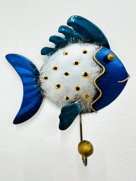 Handmade and hand painted metal fish hook in blue, silver, with gold detailing, mounted on a wall.