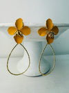 A pair of yellow floral design earrings with a golden drop pendant.