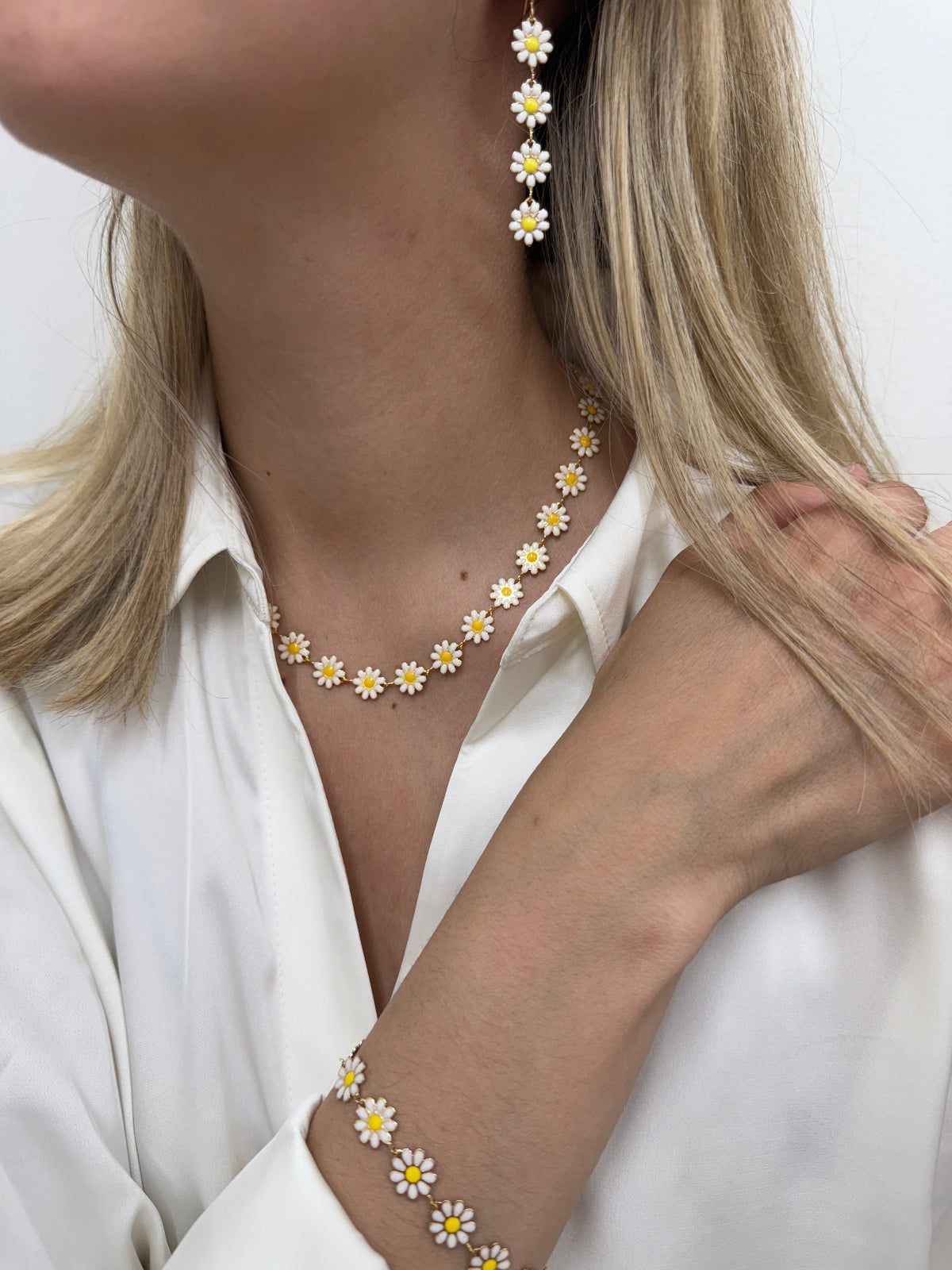 Daisy flowers bracelet on a gold-tone chain, displayed on a model.