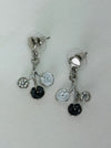White and grey floral enamel drop earrings with crystal effect glass stones on a silver-tone branch design, dispayed on a table.