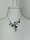 White and dark grey floral enamel necklace with crystal effect glass stones on a silver-tone chain, displayed on a mannequin.