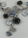 Close-up of white and grey floral enamel necklace with silver-tone chain.