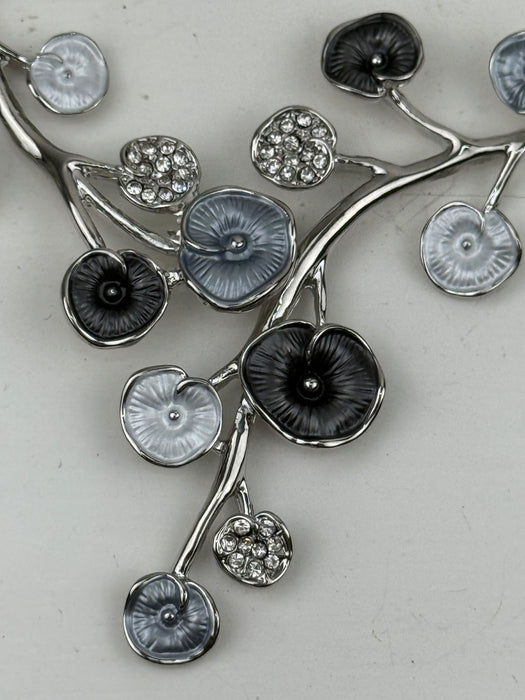 Close-up of white and grey floral enamel necklace with silver-tone chain.