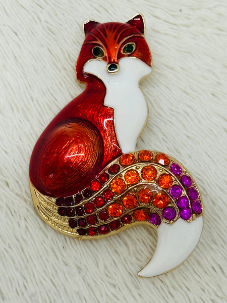 Red enamel fox brooch with crystal tail on gold-tone metal.