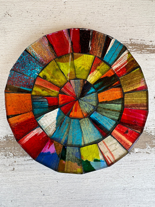 Hand-painted Fragaria mosaic coaster with red, green, blue and warm-toned glass pieces on MDF base, photographed from above on a light textured surface.