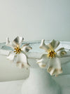 Elegant pearl white flower stud earrings with a gold-tone centre.
