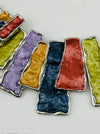 Close-up of colourfu enamel necklace with metallic panels in gunmetal, bronze, gold, lilac and lime tones.