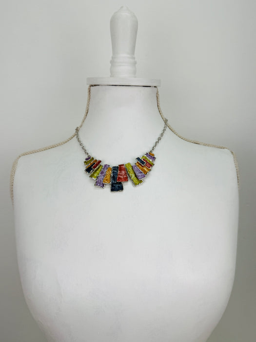 Multicoloured rectangular-shaped enamel statement necklace on a mannequin bust.